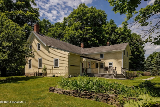 rear view of house featuring a lawn and a wooden deck