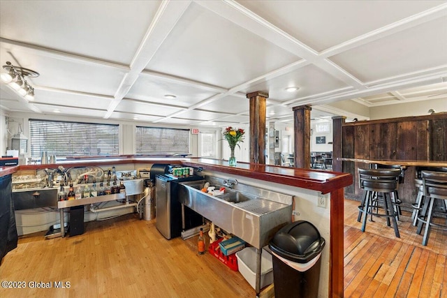 miscellaneous room with light hardwood / wood-style flooring, ornate columns, and coffered ceiling