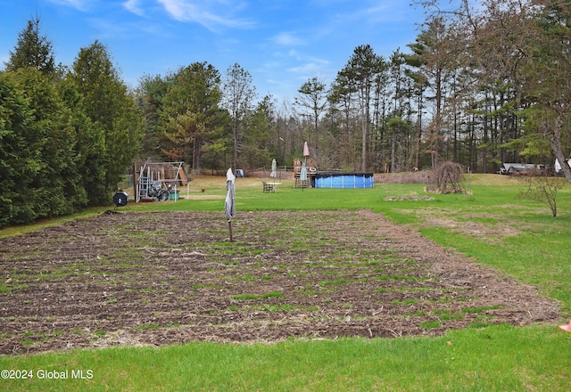 view of property's community with a pool and a lawn