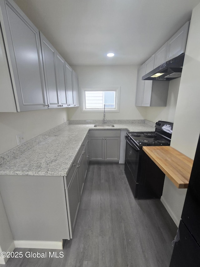 kitchen featuring dark wood finished floors, electric range, gray cabinetry, a sink, and under cabinet range hood