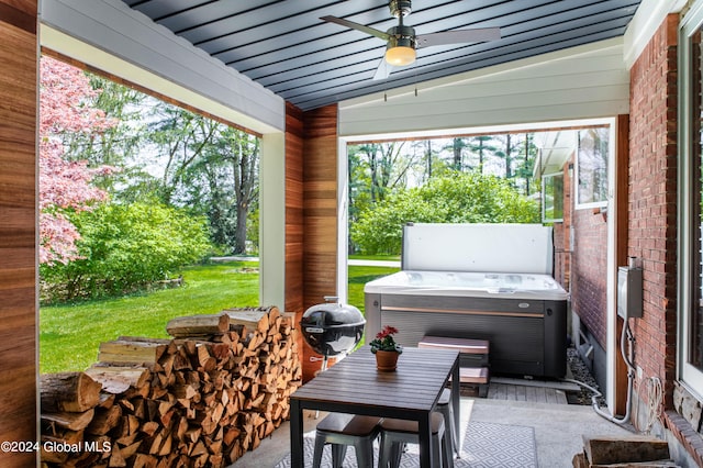 view of terrace with a hot tub and ceiling fan