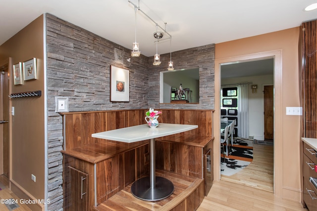 interior space featuring rail lighting, decorative light fixtures, and light wood-type flooring