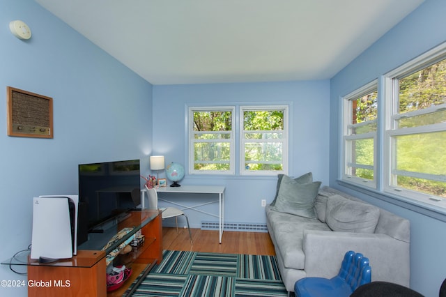 living room with wood-type flooring, plenty of natural light, and a baseboard radiator