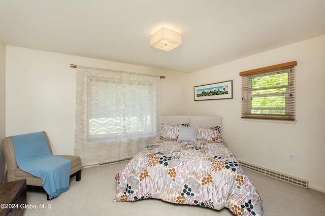 bedroom with carpet flooring and a baseboard heating unit