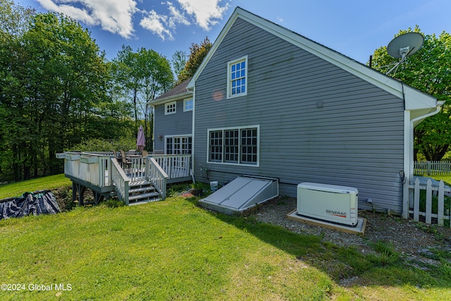 back of property with a yard and a deck