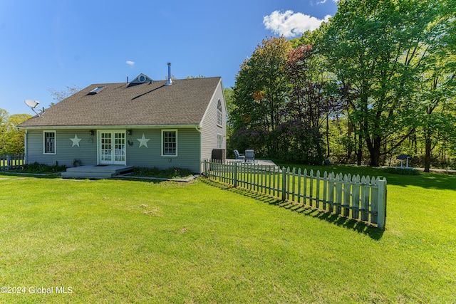 back of house with french doors and a lawn