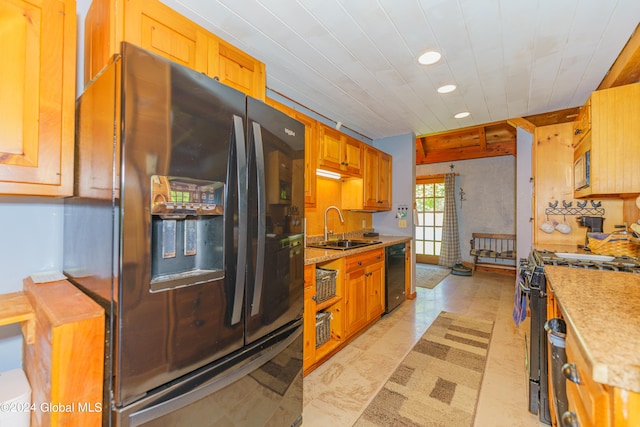 kitchen featuring sink, black appliances, and light tile flooring