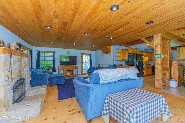 bedroom with a stone fireplace, light hardwood / wood-style floors, black refrigerator with ice dispenser, and wood ceiling