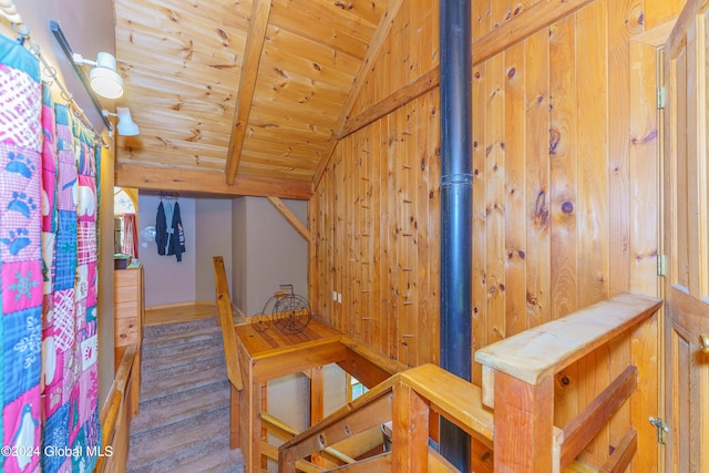 stairway featuring wooden ceiling, wooden walls, and vaulted ceiling