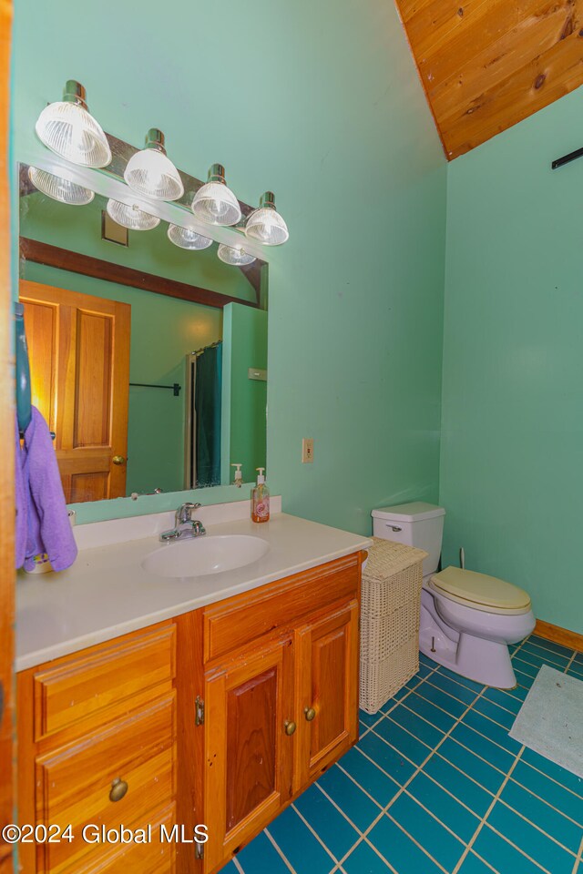 bathroom featuring tile floors, vanity, and toilet