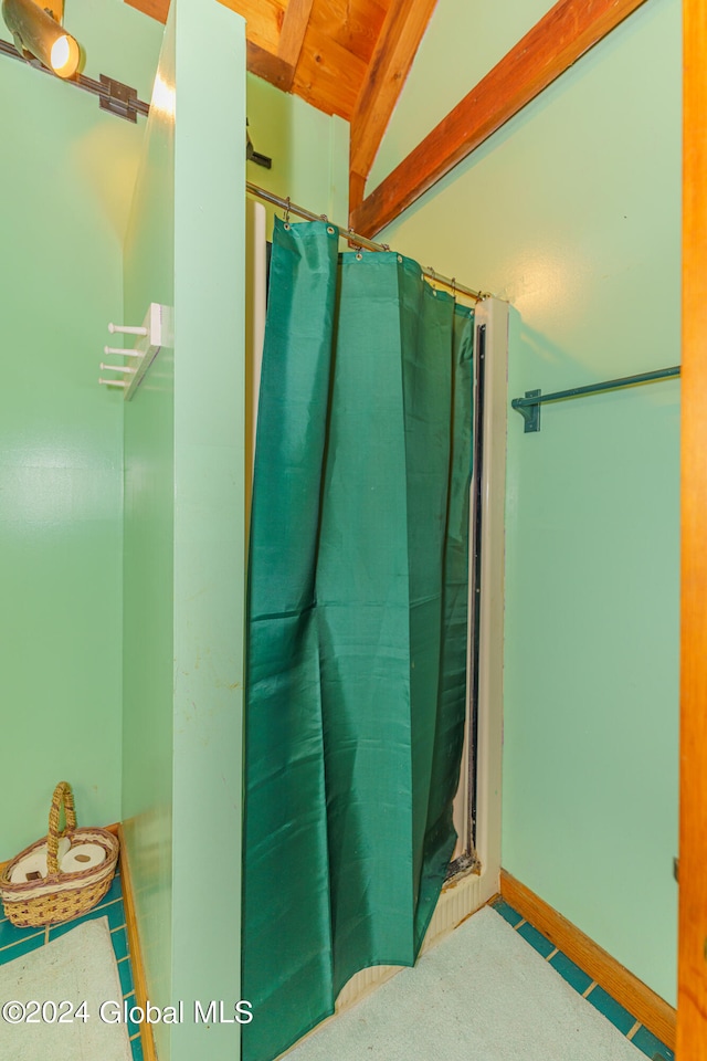 bathroom with vaulted ceiling with beams and a shower with shower curtain