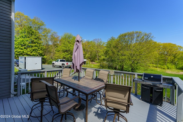 wooden terrace with a storage unit and grilling area