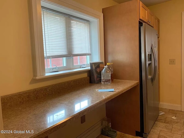 kitchen featuring stainless steel fridge and light tile floors