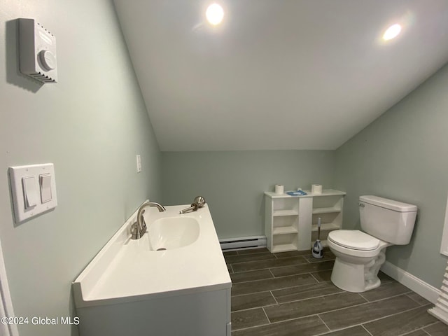 bathroom featuring vanity, a baseboard heating unit, vaulted ceiling, and toilet