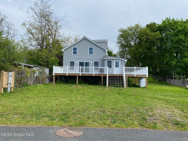 rear view of property featuring a wooden deck and a yard