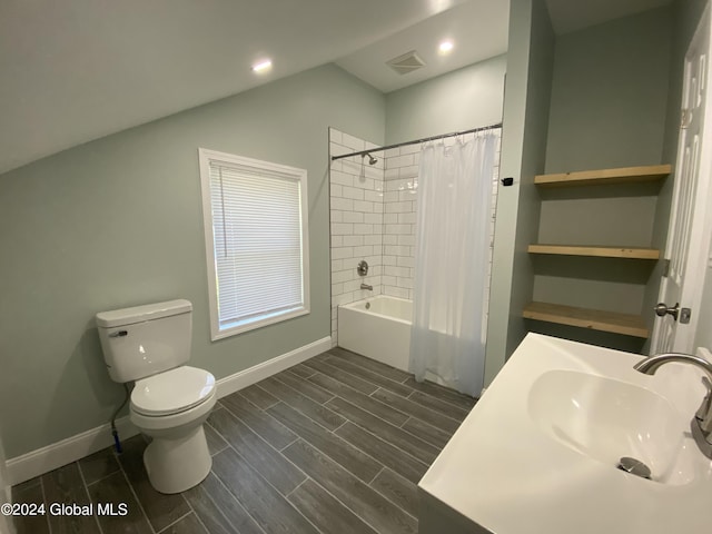 full bathroom featuring vaulted ceiling, shower / tub combo with curtain, toilet, and sink