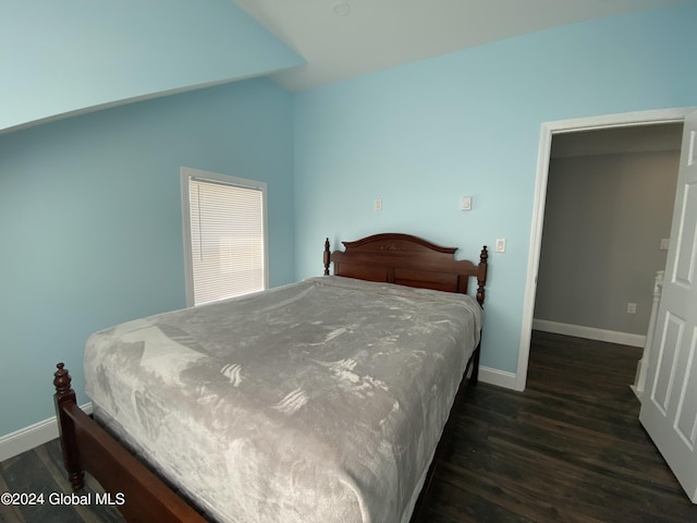 bedroom with lofted ceiling and dark hardwood / wood-style floors