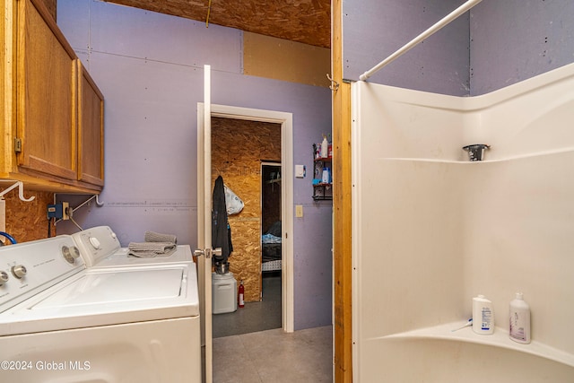 laundry area featuring separate washer and dryer and cabinets