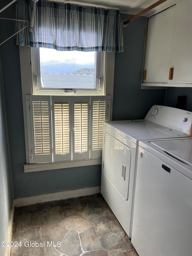 washroom featuring washer and dryer, cabinets, and tile flooring