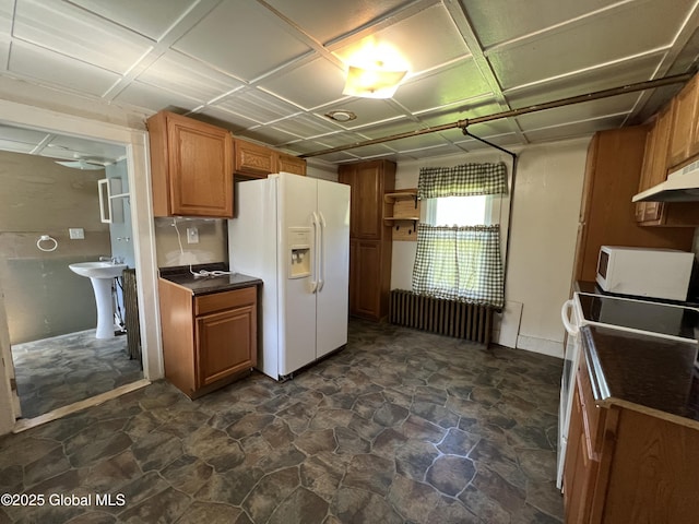 16603 State Route 22, Putnam, NY 12861 - kitchen featuring white appliances, dark countertops, brown cabinetry, and a sink