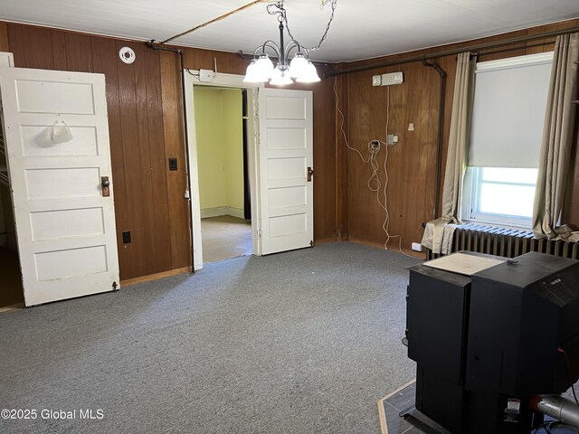 16603 State Route 22, Putnam, NY 12861 - unfurnished room with radiator, carpet flooring, a chandelier, wood walls, and baseboards