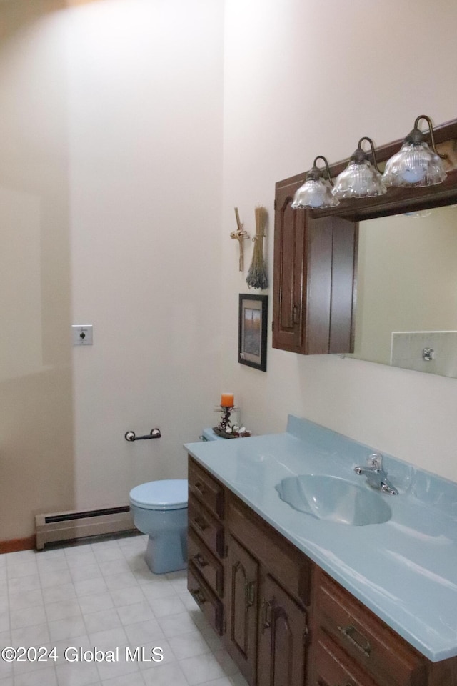 bathroom featuring a baseboard heating unit, tile floors, vanity, and toilet