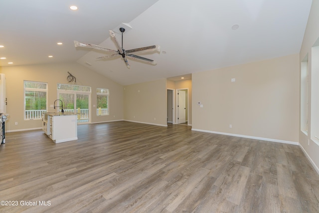 unfurnished living room featuring light wood-type flooring, high vaulted ceiling, and ceiling fan