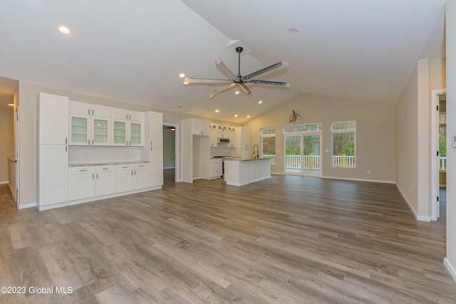 unfurnished living room featuring light wood-type flooring, ceiling fan, and lofted ceiling