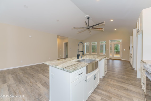 kitchen with ceiling fan, white cabinetry, sink, and a kitchen island with sink