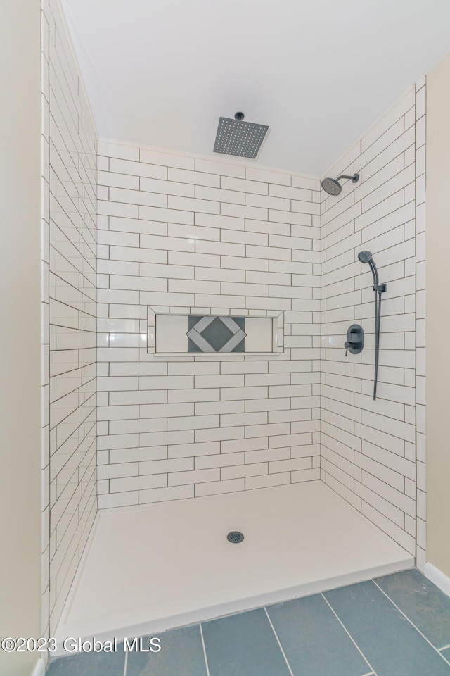 bathroom with tile patterned flooring and tiled shower