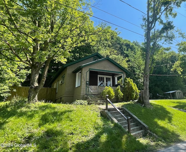 bungalow-style home with covered porch and a front lawn