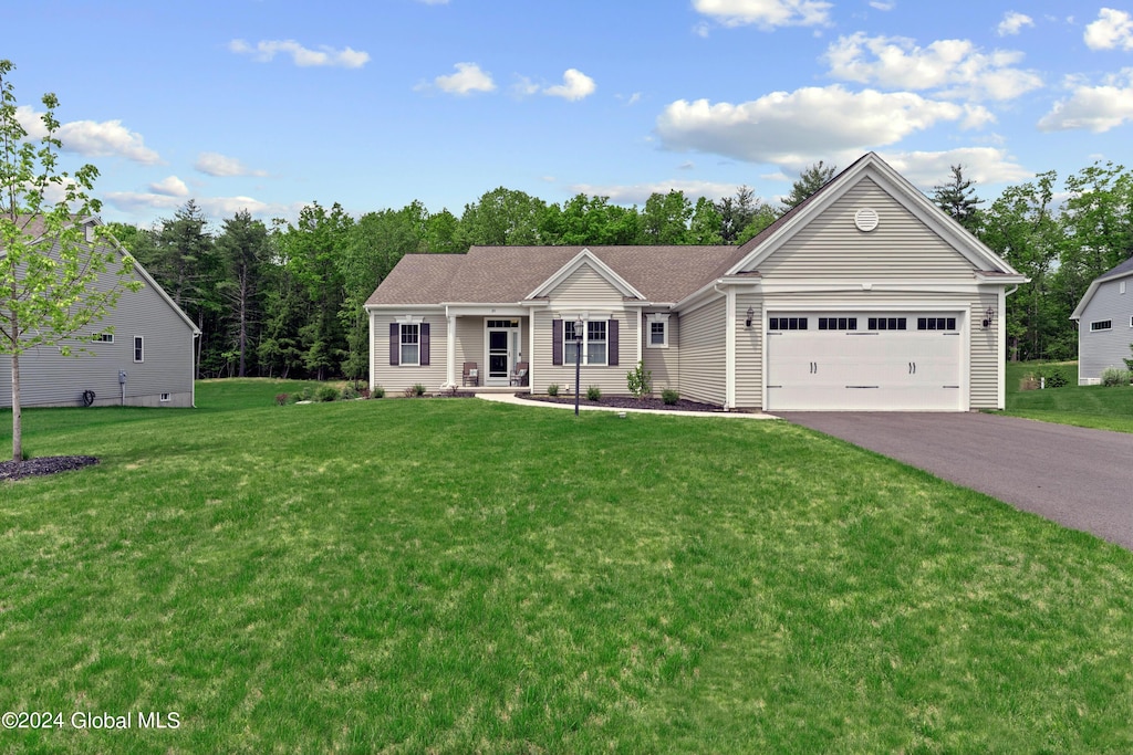 ranch-style house with driveway, a garage, and a front yard