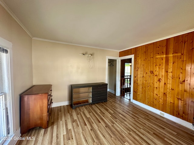 interior space with crown molding, wood walls, and wood-type flooring