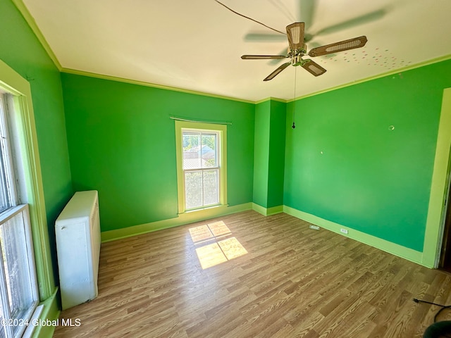 unfurnished room featuring ornamental molding, wood-type flooring, and ceiling fan