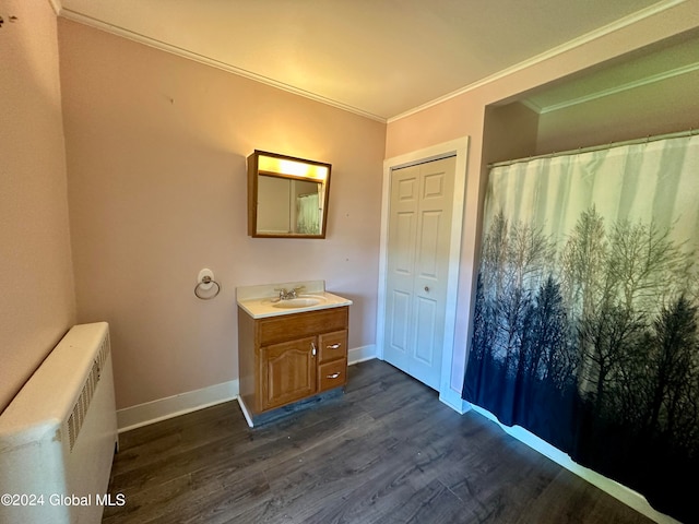 bathroom with hardwood / wood-style floors, vanity, crown molding, and radiator heating unit