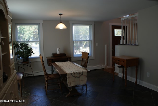 dining room featuring a baseboard heating unit and a healthy amount of sunlight