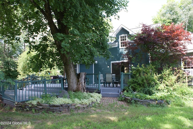 view of property hidden behind natural elements featuring a wooden deck