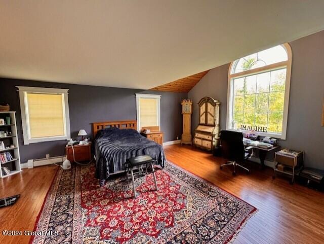 bedroom featuring hardwood / wood-style floors, vaulted ceiling, and a baseboard heating unit