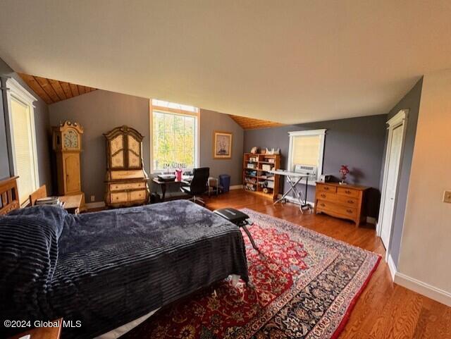 bedroom with lofted ceiling and hardwood / wood-style flooring