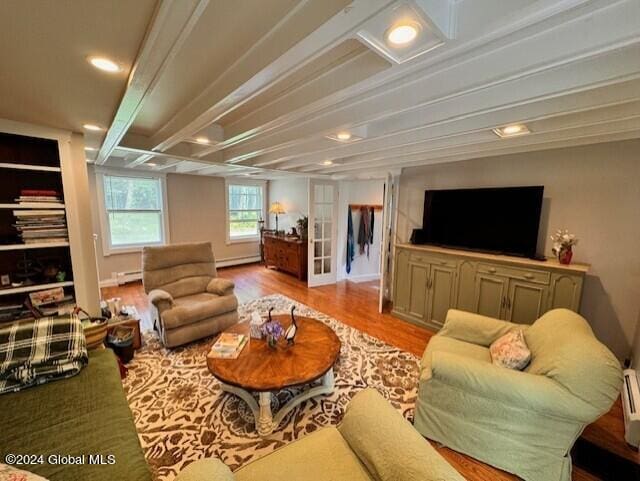 living room featuring french doors, a baseboard radiator, and light wood-type flooring