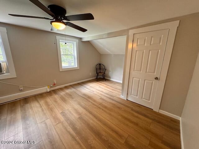 additional living space with ceiling fan, light hardwood / wood-style flooring, and lofted ceiling