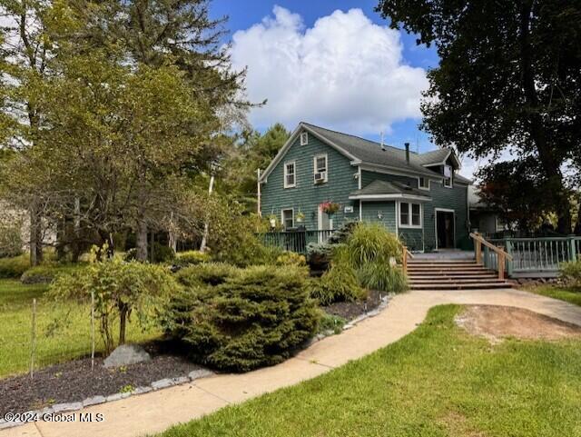 back of property featuring a lawn and a deck