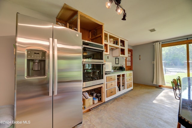 kitchen featuring track lighting, concrete flooring, and stainless steel appliances