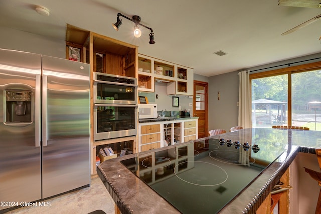 kitchen with appliances with stainless steel finishes, beverage cooler, and rail lighting