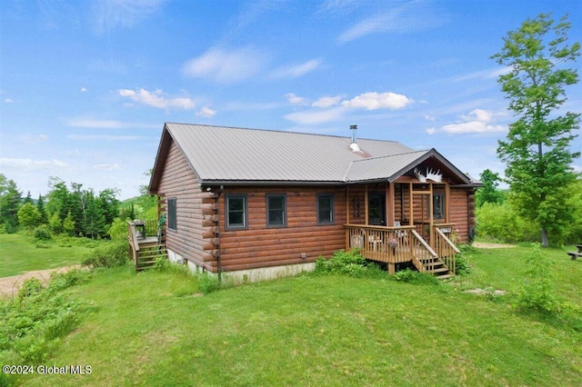 rear view of property featuring a lawn