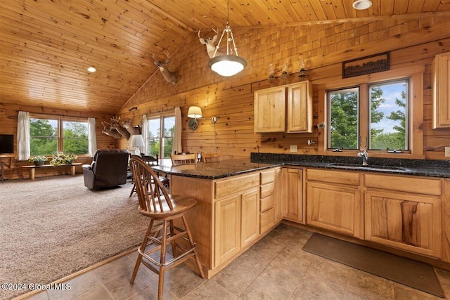 kitchen featuring wooden ceiling, sink, a breakfast bar area, and light tile floors