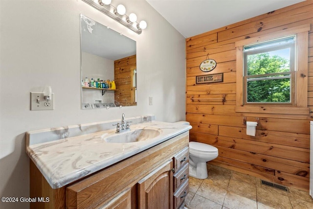 bathroom featuring tile flooring, toilet, wooden walls, and oversized vanity