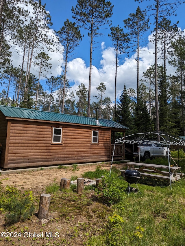 view of home's exterior with log veneer siding and metal roof