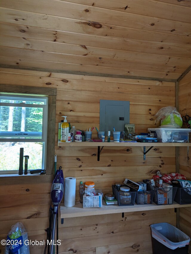 interior space featuring vaulted ceiling and wood walls