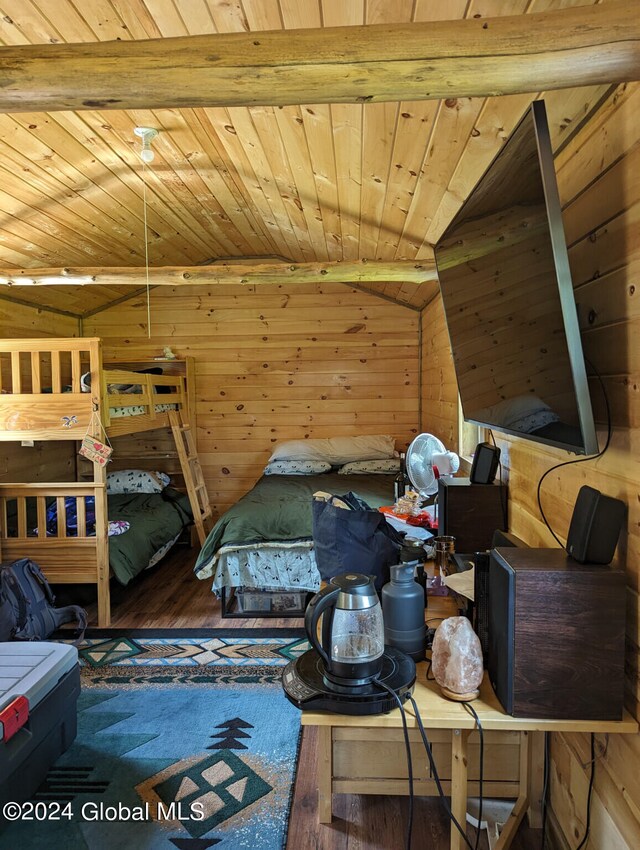 bedroom featuring wood walls, hardwood / wood-style floors, wood ceiling, and lofted ceiling